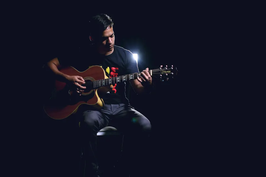 Gitarist speelt akoestische gitaar in warm licht