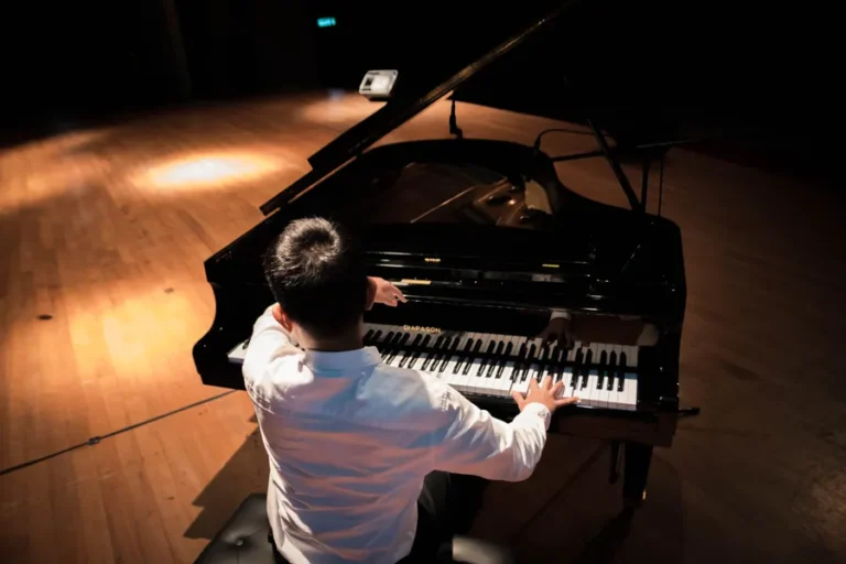 Pianist speelt op een zwarte vleugel, van achteren gezien